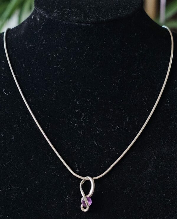 Silver necklace and purple pendant